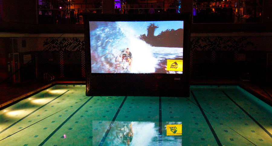 Inflatable outdoor movie screen floating in a pool
